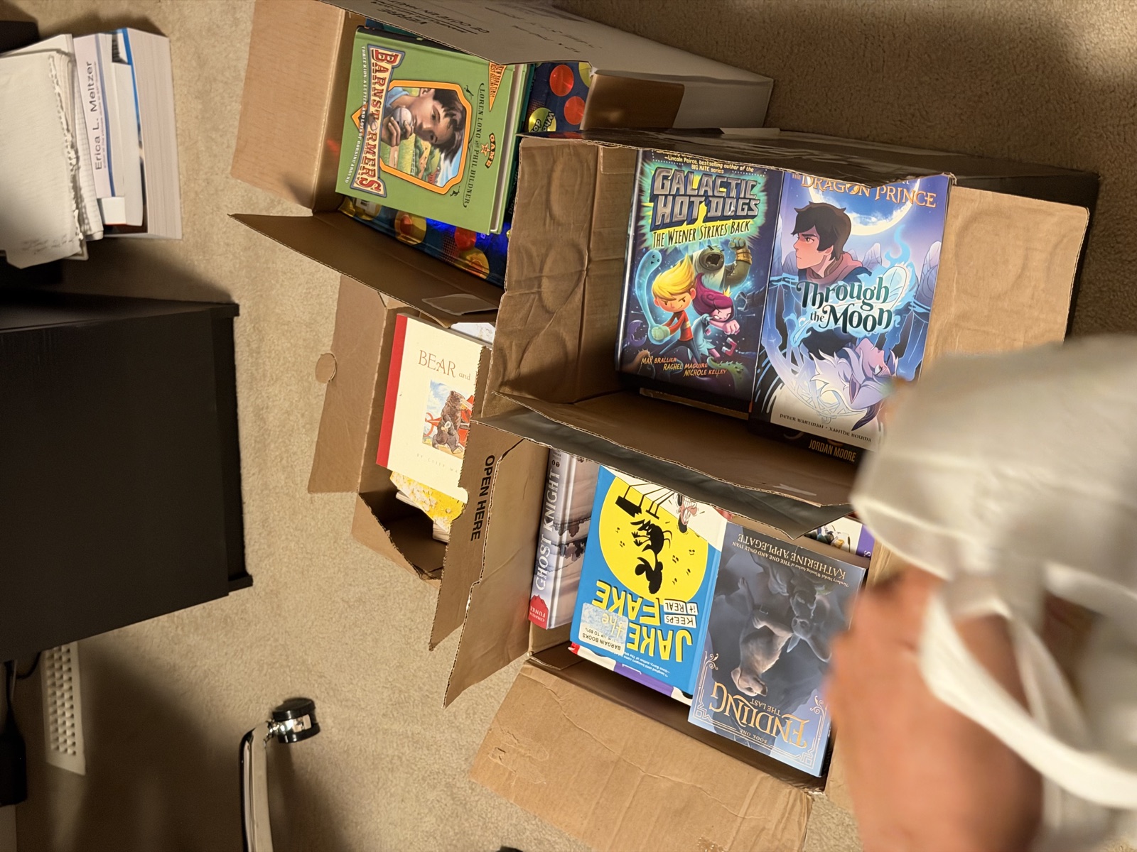 Boxes of children's books being sorted at home before delivery